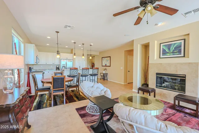 a living room with furniture a fireplace and a chandelier