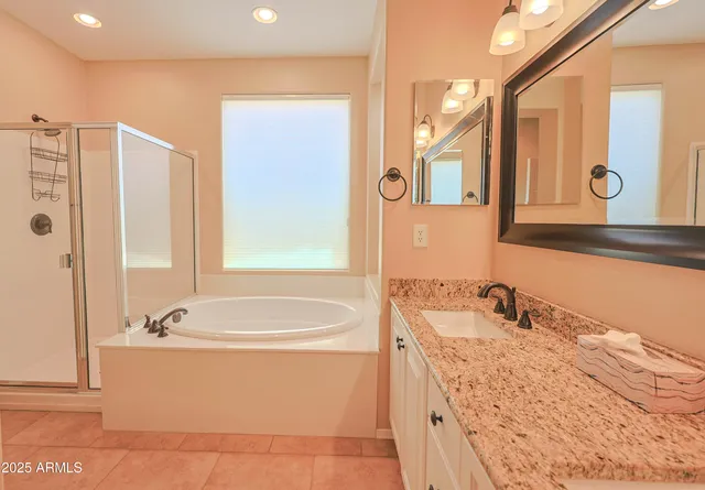 a bathroom with a granite countertop tub sink and mirror