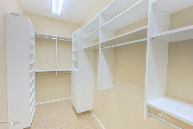 a view of walk in closet with empty racks