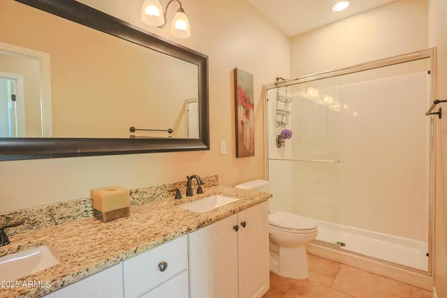 a bathroom with a granite countertop sink mirror vanity and toilet