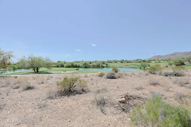 a view of a lake with beach and green space