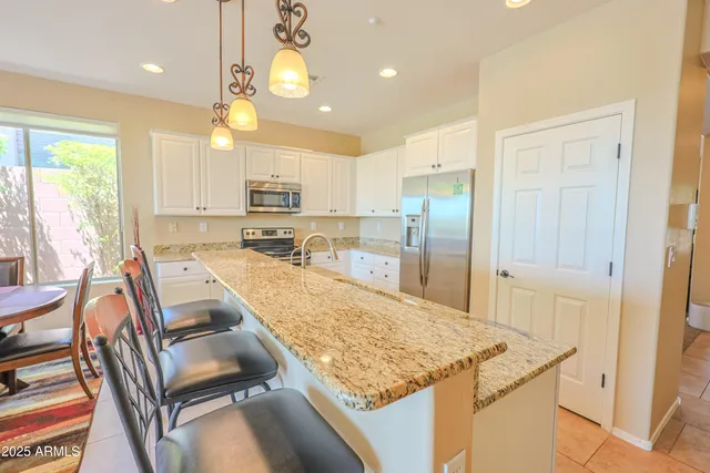 a large kitchen with kitchen island a large counter space and stainless steel appliances
