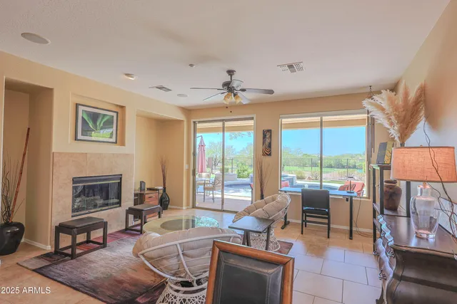 a living room with furniture a fireplace and a floor to ceiling window