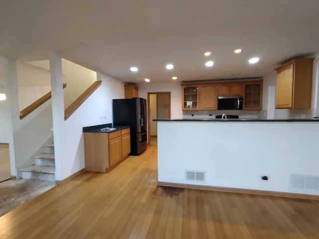 a large kitchen with stainless steel appliances kitchen island granite countertop a stove top oven a sink and dishwasher