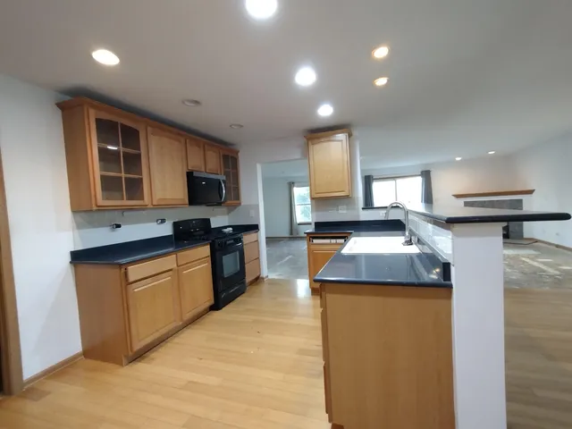 a kitchen with granite countertop a sink and a stove top oven