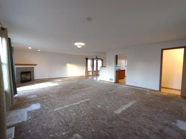 a view of empty room with a fireplace and windows