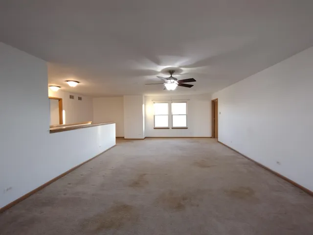 a view of a livingroom with a ceiling fan and window