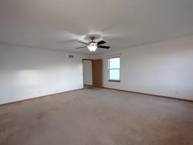 a view of a livingroom with a ceiling fan and window