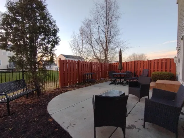 a white bench sitting in backside of a house with wooden fence