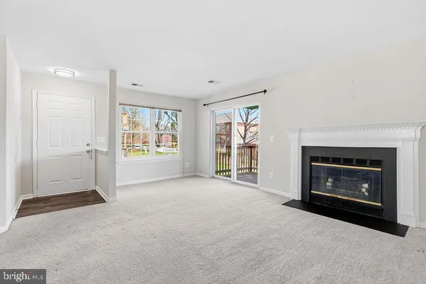 a view of an empty room with a fireplace and a window