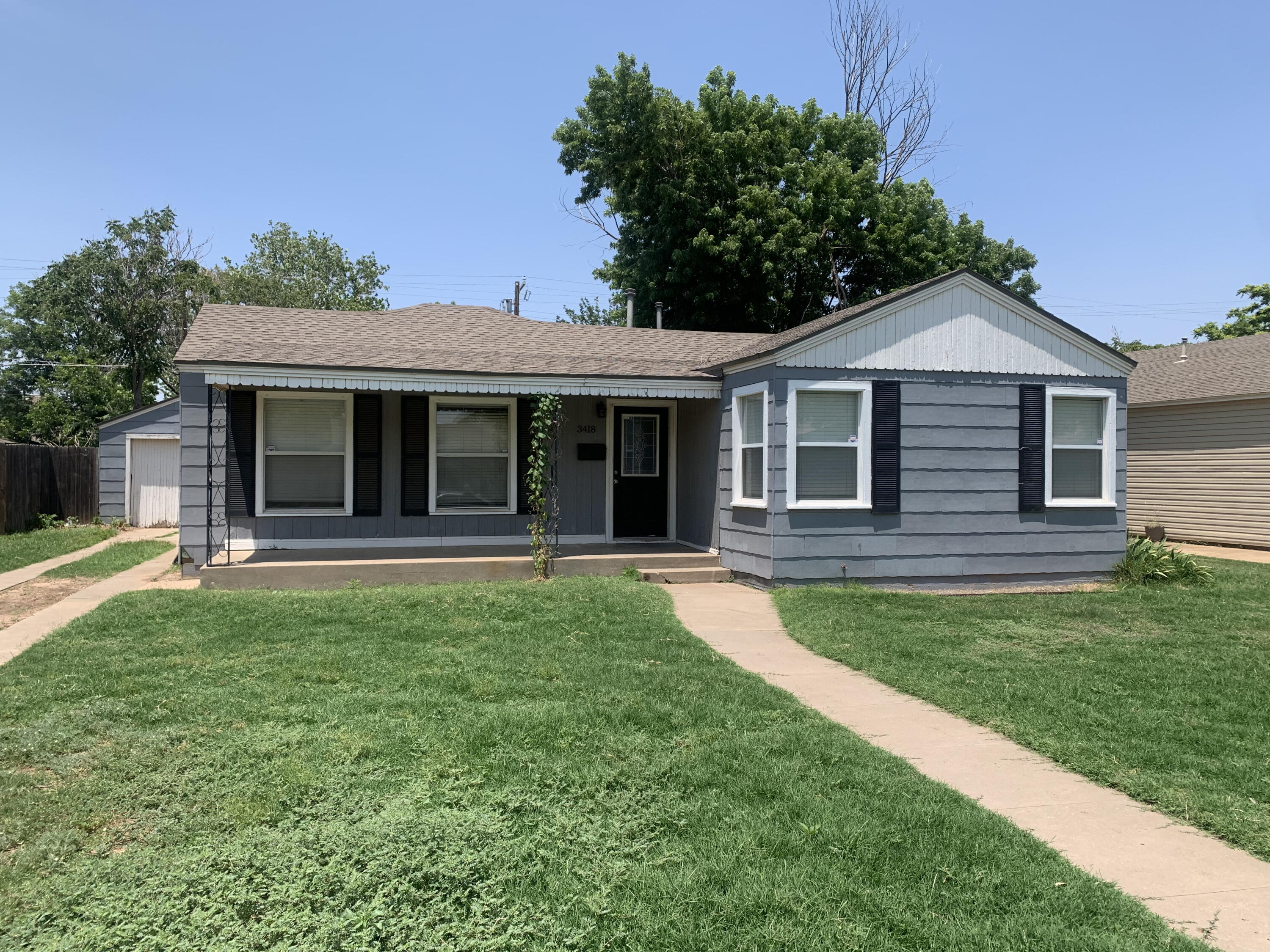 3418 26th Street Lubbock, TX 79410 - Photo 1 of 16 a front view of a house with a garden