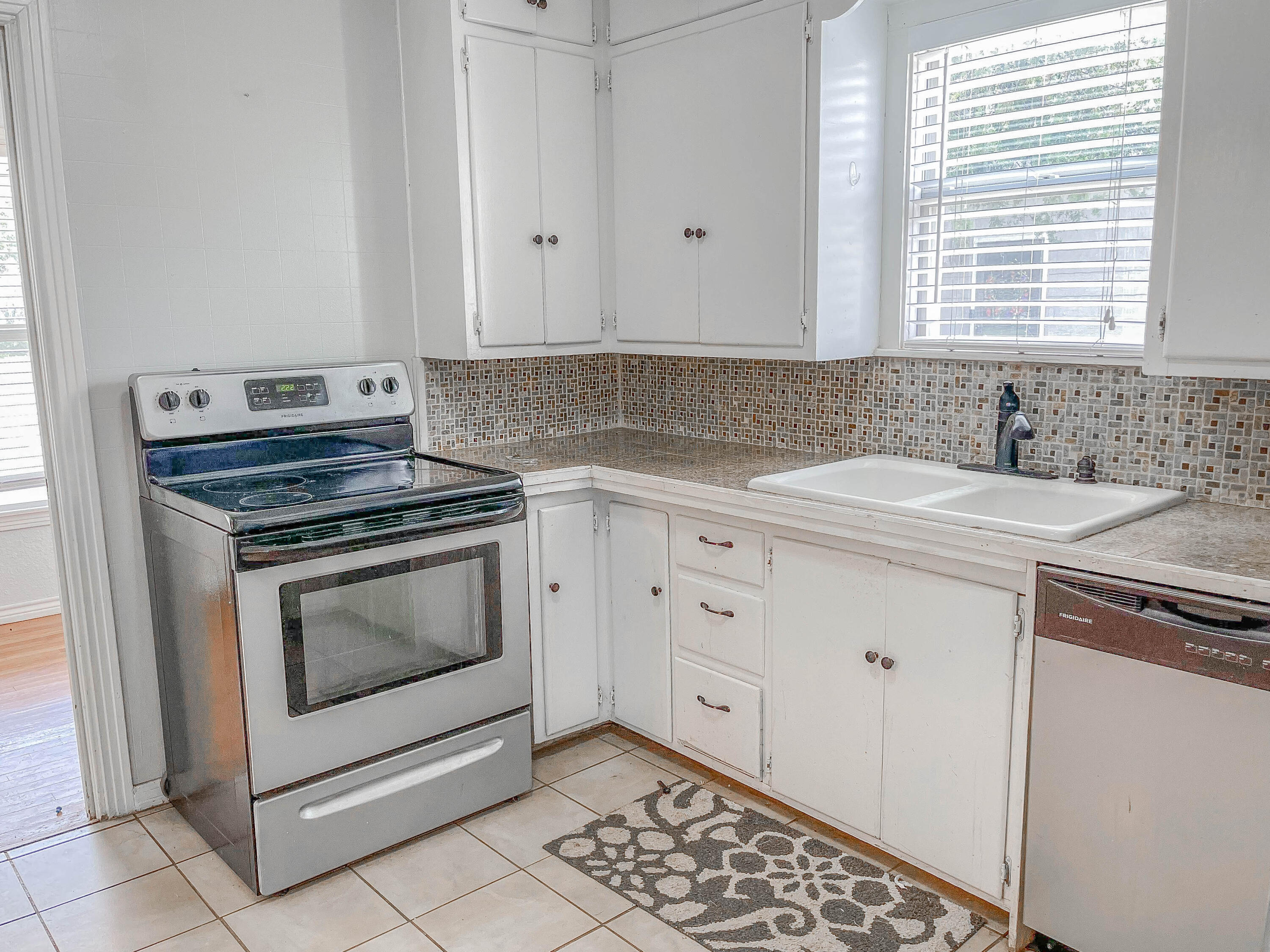 3418 26th Street Lubbock, TX 79410 - Photo 11 of 16 a kitchen with granite countertop white cabinets and white appliances