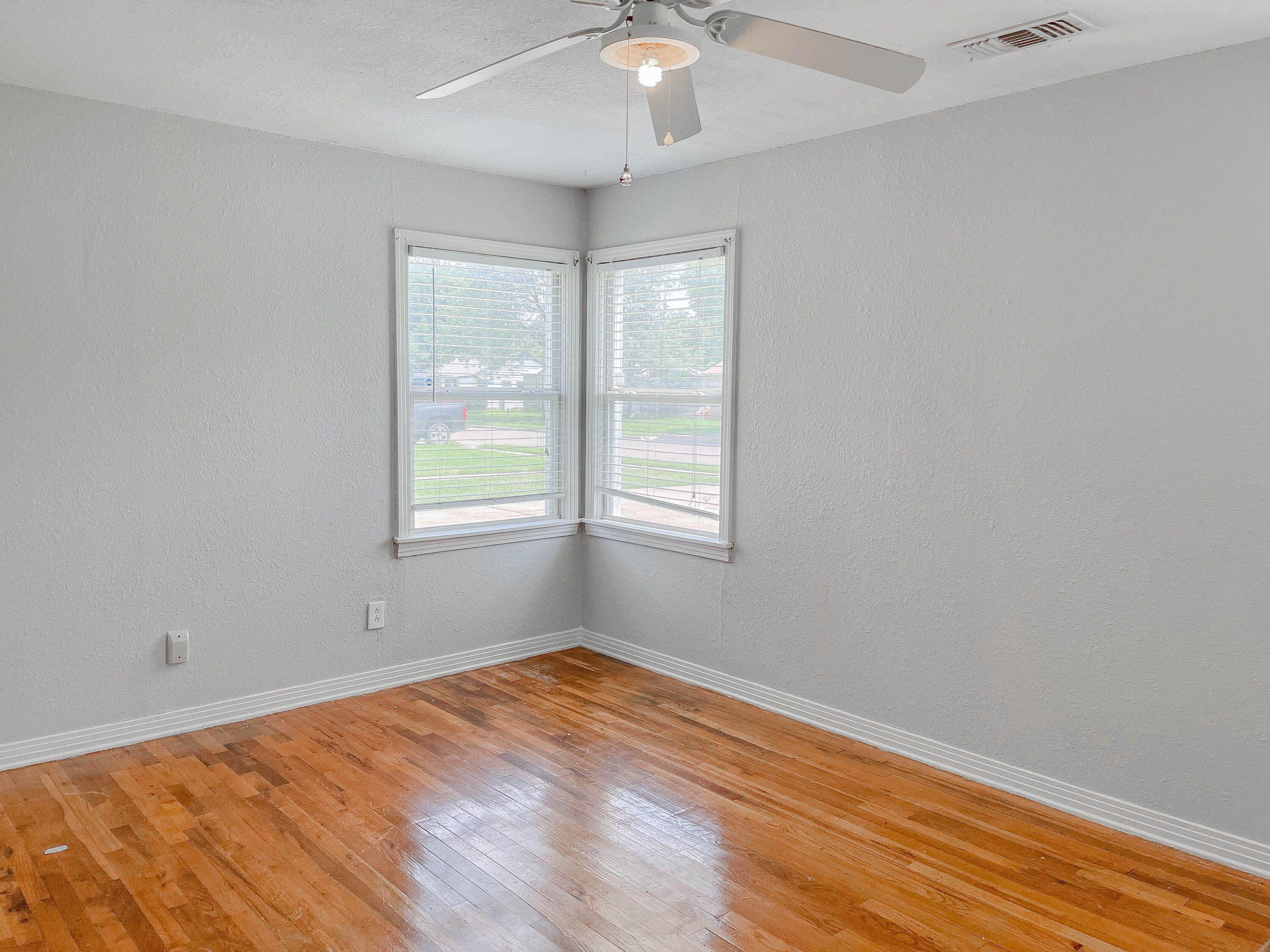 3418 26th Street Lubbock, TX 79410 - Photo 6 of 16 a view of an empty room with wooden floor and a window