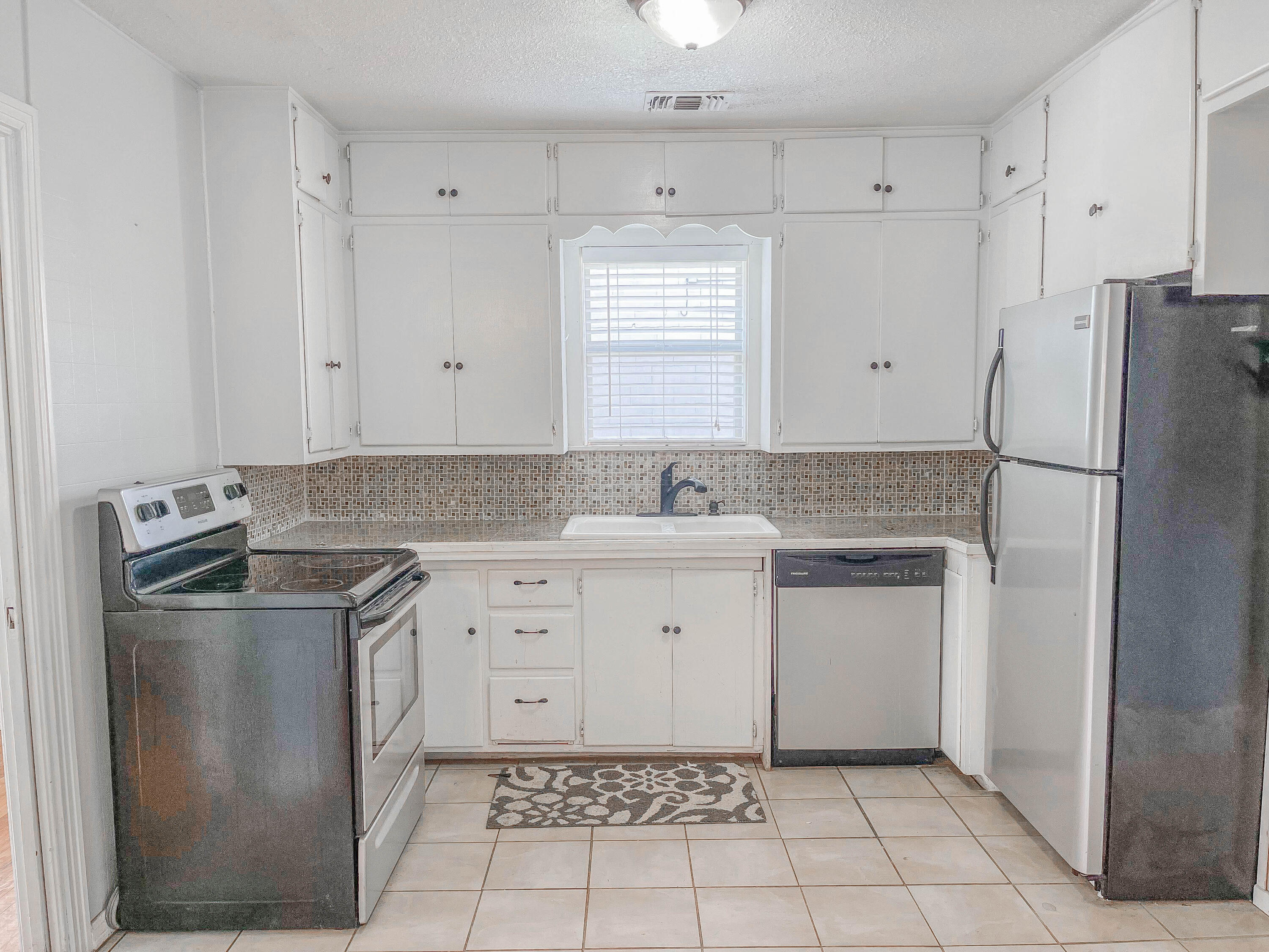 3418 26th Street Lubbock, TX 79410 - Photo 10 of 16 a kitchen with a stove sink and refrigerator