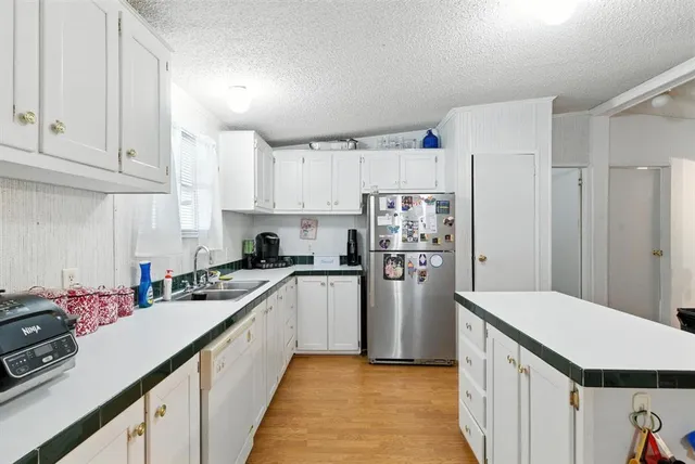 a kitchen with granite countertop a sink cabinets and wooden floor