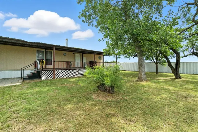 a backyard of a house with table and chairs