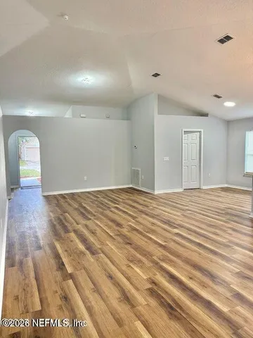 a view of empty room with wooden floor
