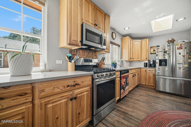 1931 Lousetown Road Reno, NV 89521 - Photo 30 of 51 a kitchen with stainless steel appliances granite countertop a stove top oven a refrigerator a sink and dishwasher with wooden floor