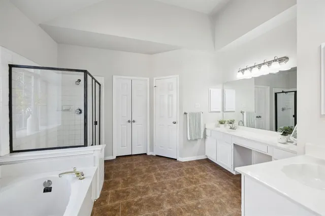 a spacious bathroom with a double vanity sink mirror and shower