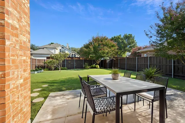 a table and chairs with the view of garden