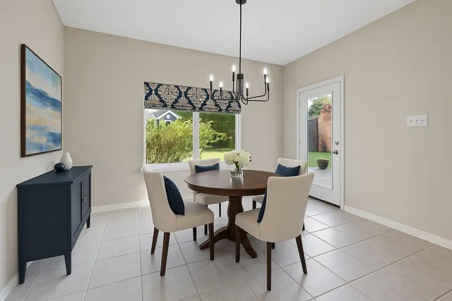 a dining room with furniture a chandelier and window