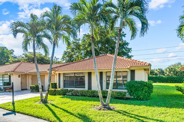 a view of a house with a yard and potted plants