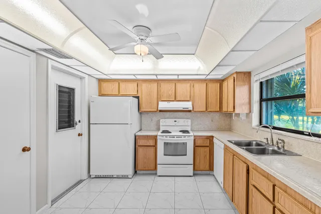 a kitchen with a sink window and cabinets
