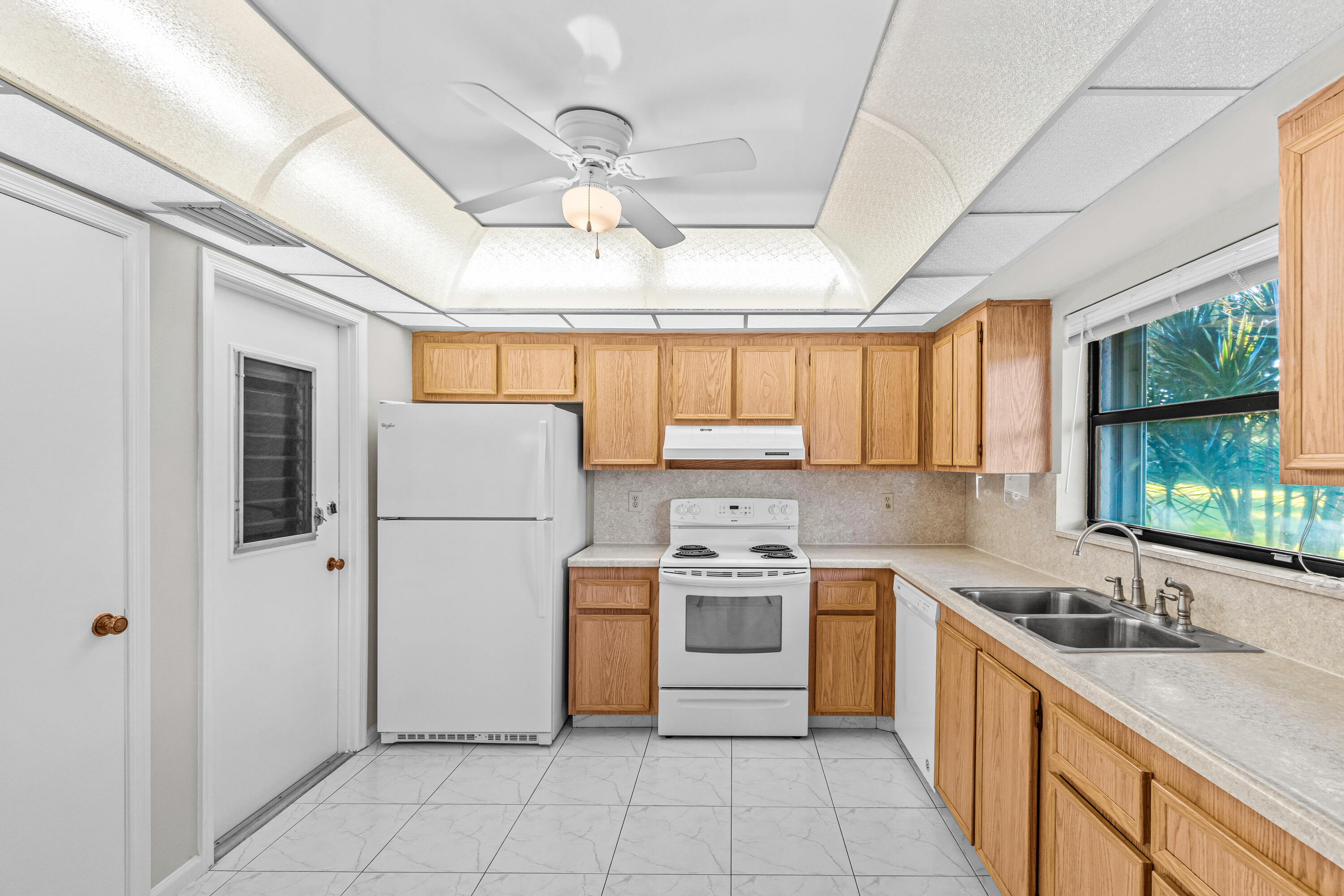4640 Rosewood Tree Court, Unit B Boynton Beach, FL 33436 - Photo 12 of 27 a kitchen with a stove a sink dishwasher a refrigerator and cabinets