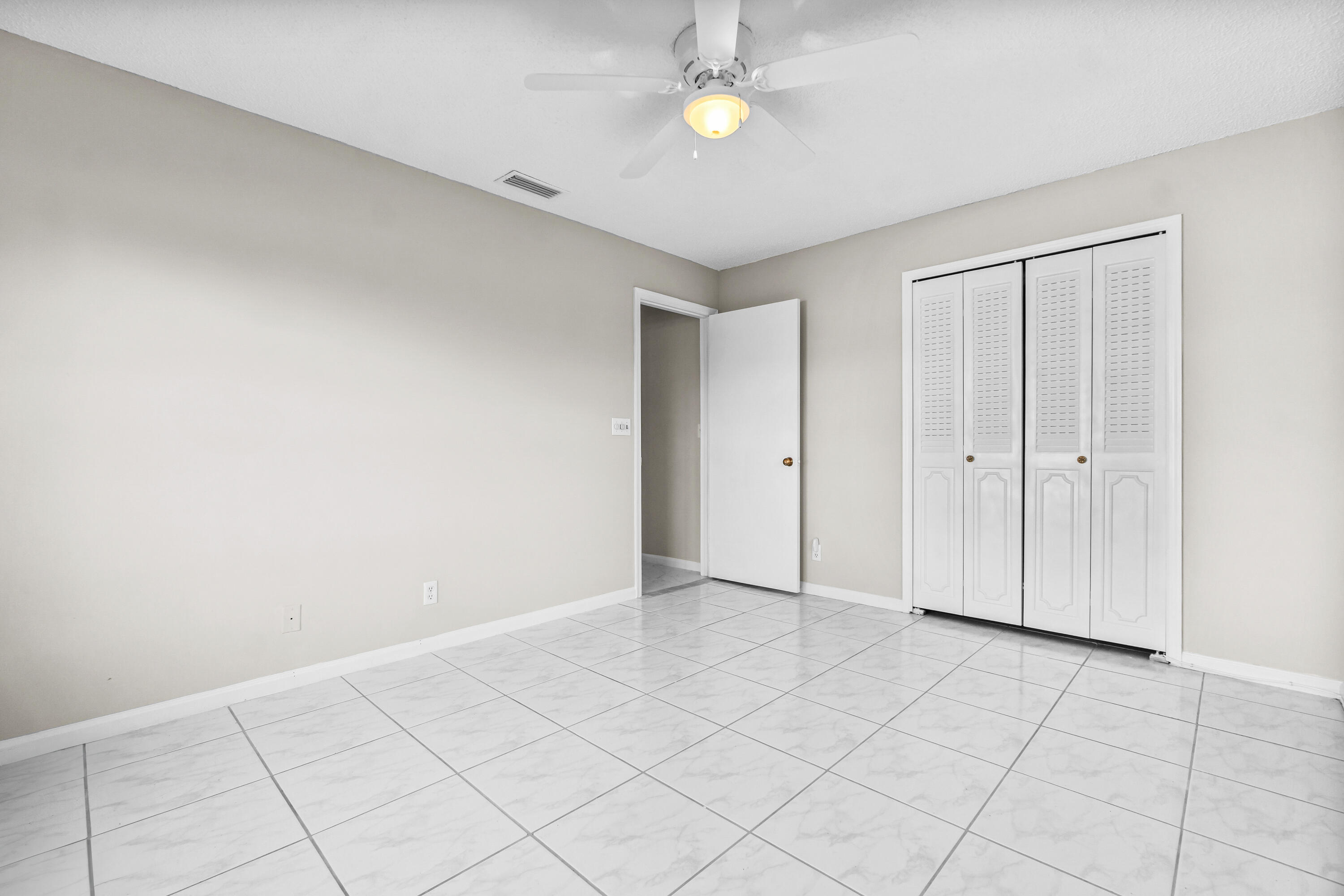 4640 Rosewood Tree Court, Unit B Boynton Beach, FL 33436 - Photo 22 of 27 an empty room with a chandelier fan