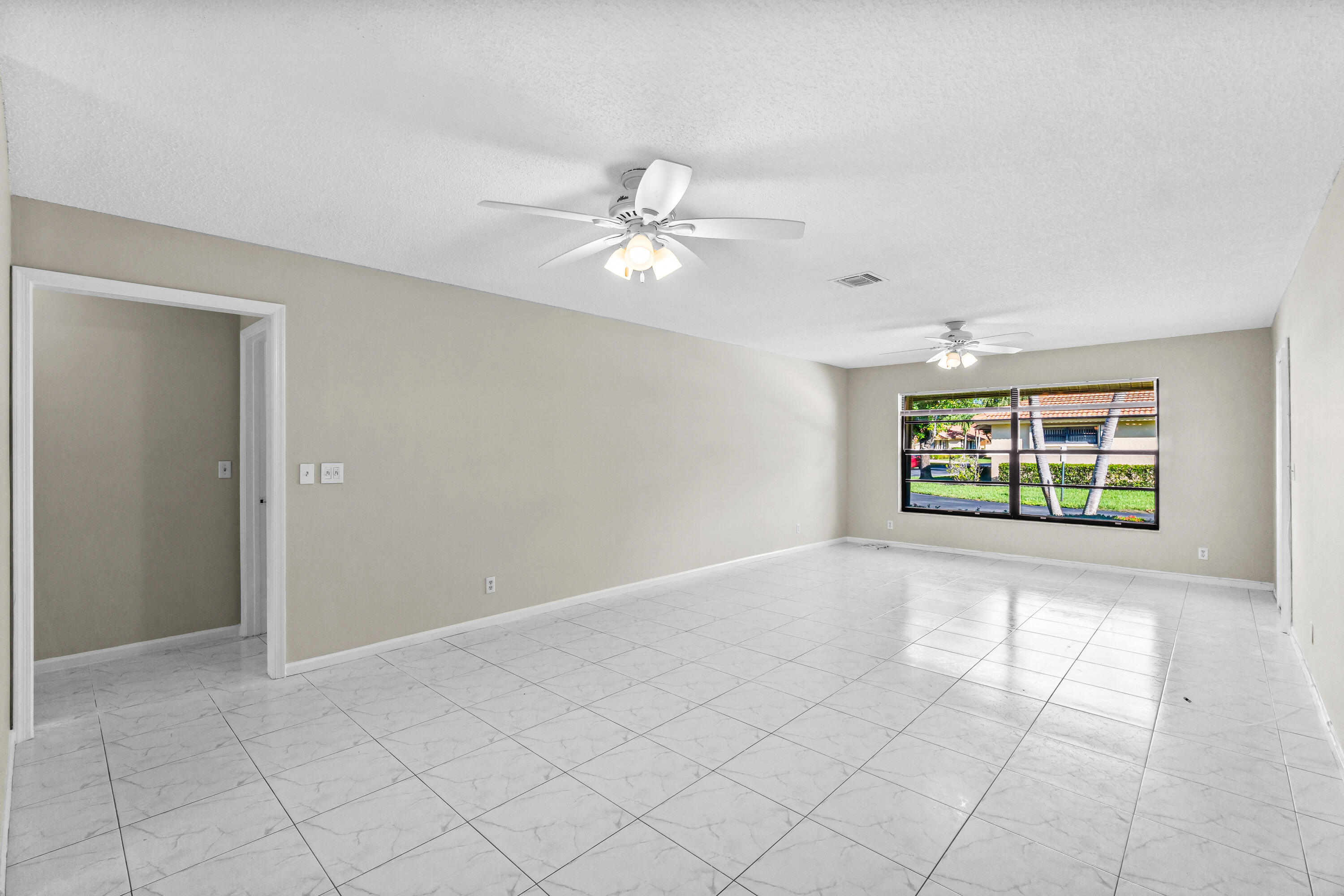 4640 Rosewood Tree Court, Unit B Boynton Beach, FL 33436 - Photo 6 of 27 an empty room with windows and fan