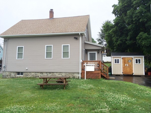2 Burton Court Worcester, MA 01607 - Photo 3 of 25 a front view of a house with a garden and chairs