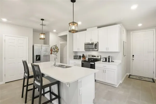 a large kitchen with kitchen island a large counter space a sink appliances and living room view