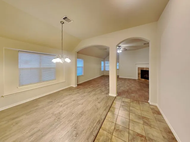 a view of empty room with wooden floor