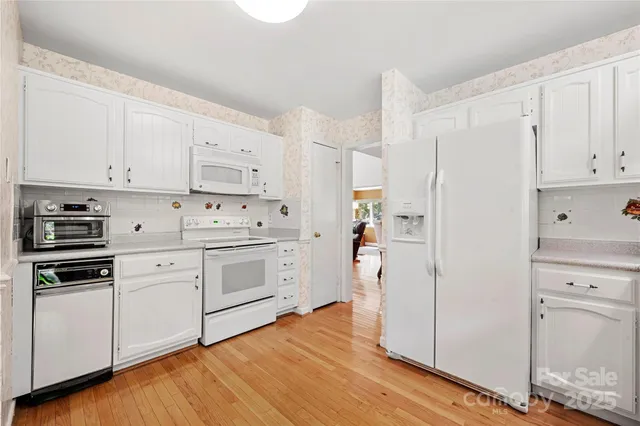 a kitchen with white cabinets and white appliances