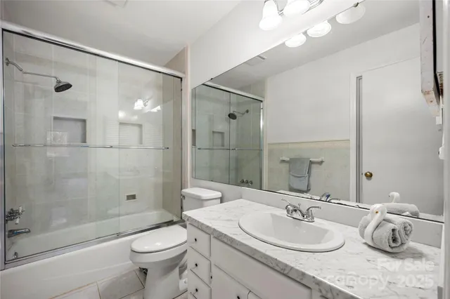 a bathroom with a granite countertop sink a toilet and shower
