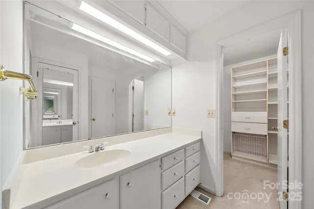 a spacious bathroom with a shower sink and mirror