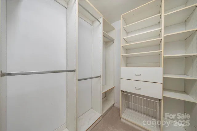 a view of walk in closet with empty racks