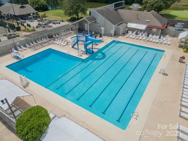 a view of a house with pool and chairs