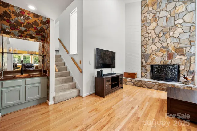 a view of a livingroom with wooden floor and a fireplace
