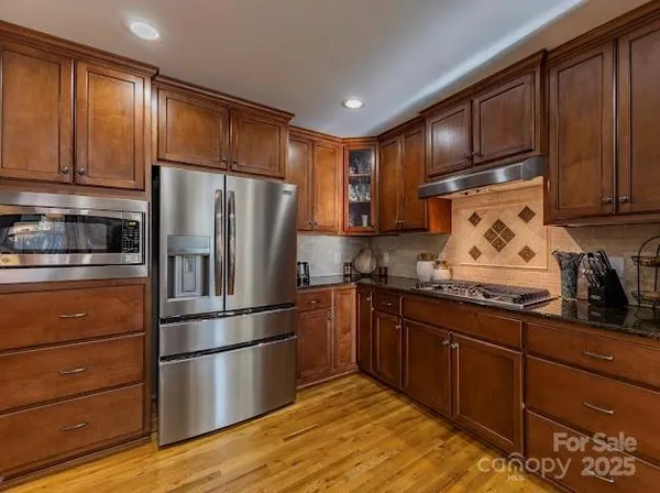 a kitchen with kitchen island granite countertop a sink stove and refrigerator