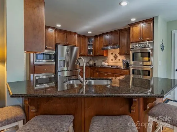 a view of a dining room and livingroom with furniture wooden floor a chandelier