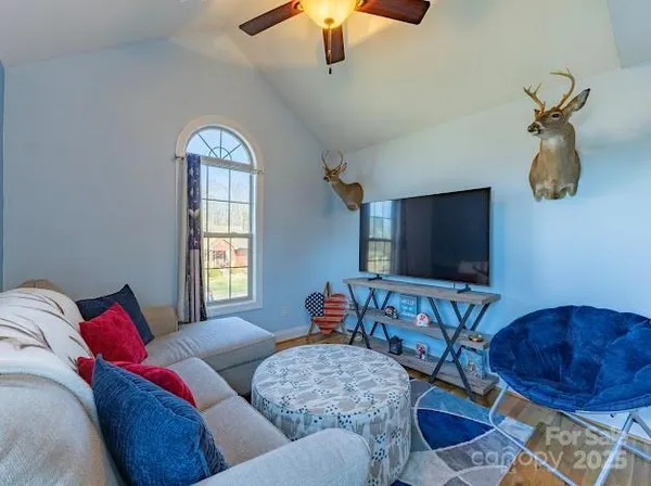 a living room with furniture a fireplace and a flat screen tv