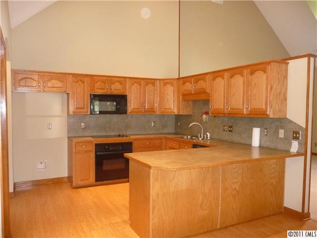 4519 Wolf Pond Road Monroe, NC 28112 - Photo 2 of 16 a kitchen with stainless steel appliances granite countertop a sink a stove and a refrigerator with cabinets