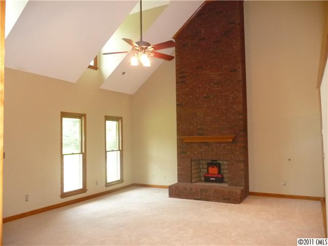 4519 Wolf Pond Road Monroe, NC 28112 - Photo 4 of 16 a view of an empty room with chandelier fan and fire place