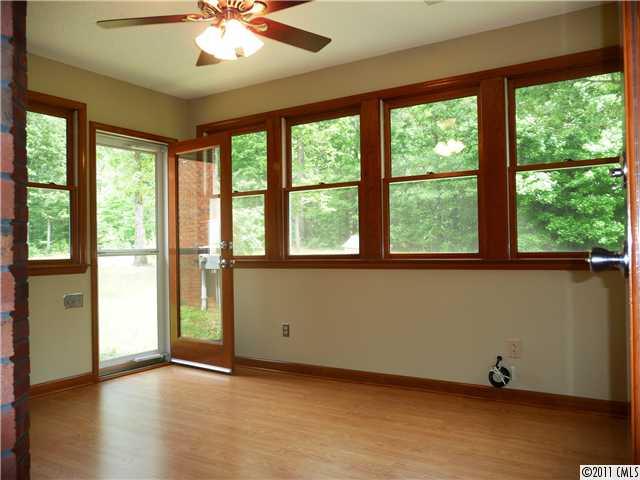 4519 Wolf Pond Road Monroe, NC 28112 - Photo 6 of 16 a view of an empty room with a window and wooden floor