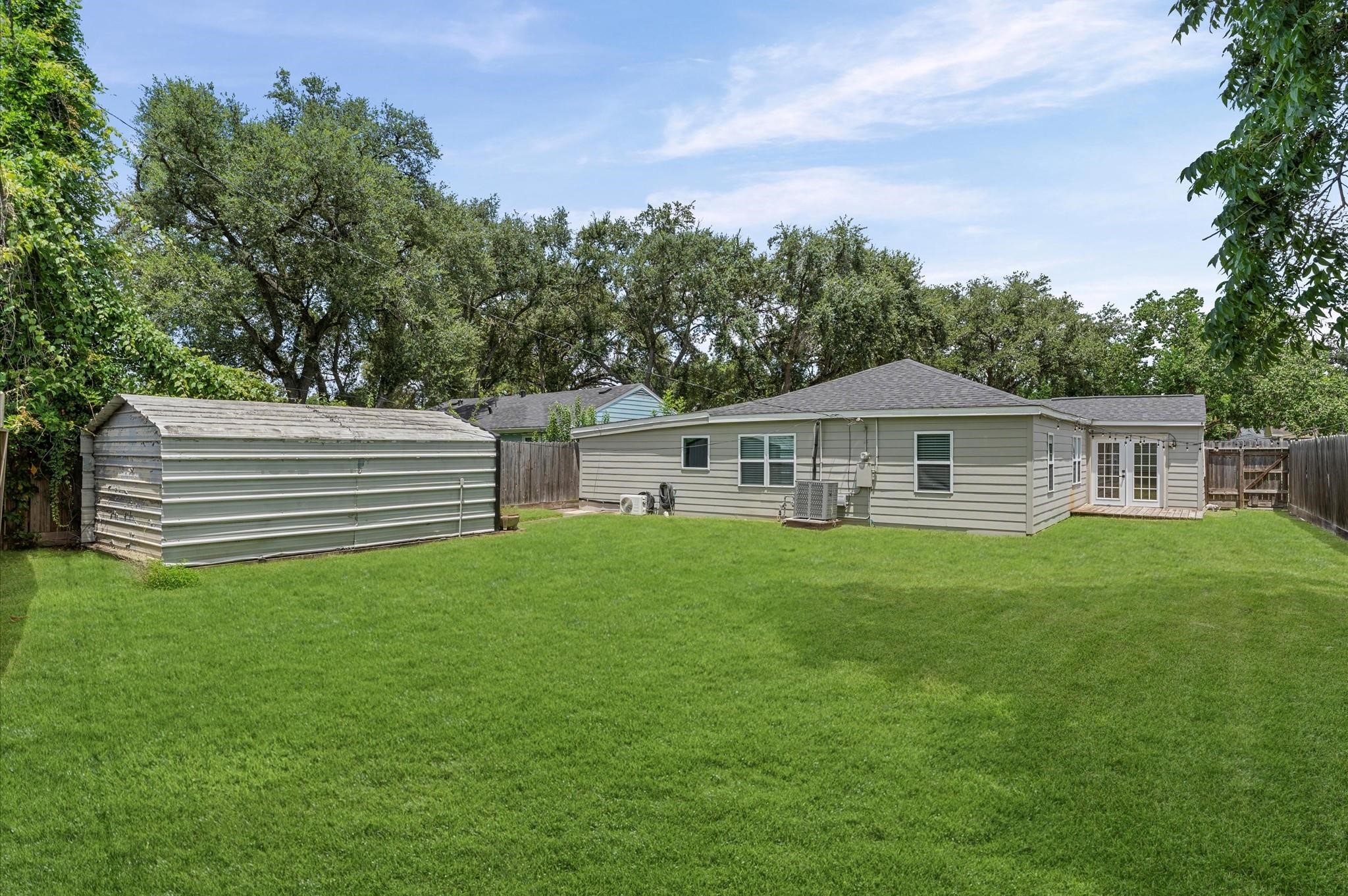 4826 Culmore Drive Houston, TX 77021 - Photo 19 of 21 String lights, French doors, and a wood deck set the scene for casual dinners, children's playdates, and easy weekend lounging with a fully fenced backyard for privacy. The expansive backyard is perfect for a garden, a playscape, or even a pool, plus a useful storage shed to keep everything tidy and covered.