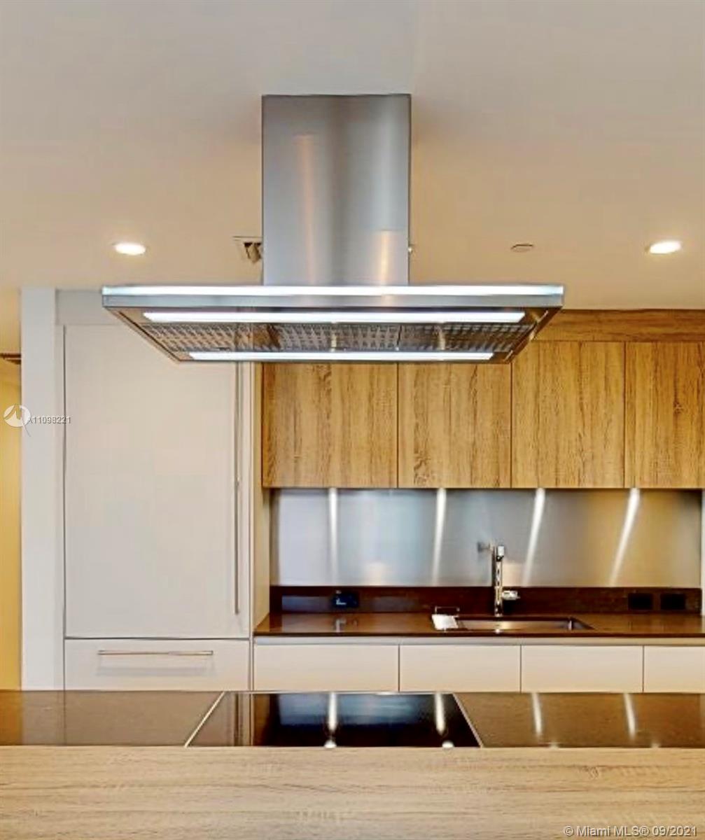 1000 Brickell Plaza, Unit 4907 Miami, FL 33131 - Photo 17 of 26 a kitchen with stainless steel appliances kitchen island granite countertop a sink and a stove