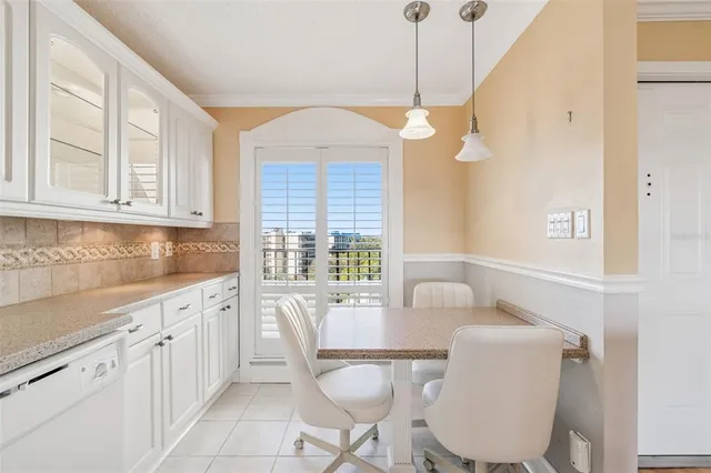 a view of a dining room and livingroom with furniture wooden floor a chandelier