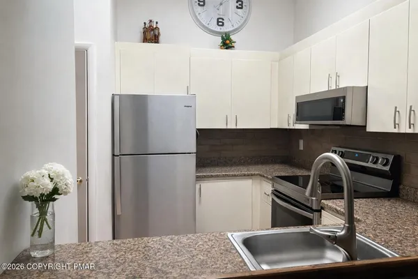 a kitchen with a refrigerator and a sink