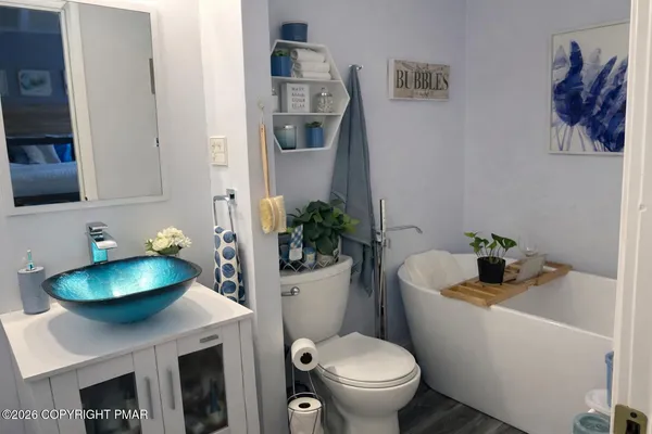 a bathroom with a sink a toilet and a mirror
